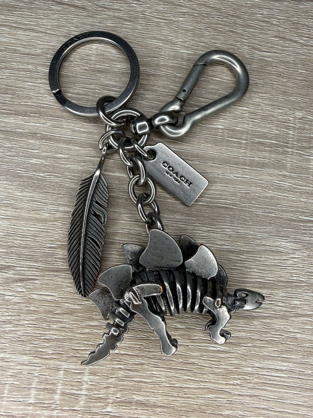 COACH Silver-Tone Stegosaurus dinosaur & Feather Keychain